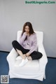 A woman sitting on a white chair in a room.