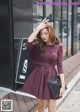 A woman in a purple dress is walking down the street.