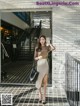 A woman in a beige skirt is walking down the street.