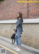 A woman standing in front of a brick wall.