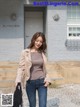 A woman in jeans and a jacket is walking down the street.