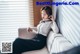 A woman sitting on a couch talking on a cell phone.