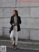 A woman standing in front of a concrete wall.