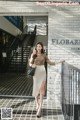 A woman in a beige skirt is walking down the stairs.