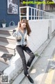 A woman sitting on the steps of a building talking on a cell phone.