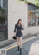 a woman in a black and white striped dress is walking down the street