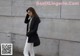 A woman standing in front of a concrete wall.