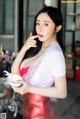 A woman in a red dress holding a bowl of food.