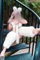 A woman in a white furry outfit sitting on a set of stairs.