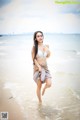 A woman in a bikini standing in the ocean.