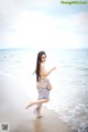 A woman walking on the beach near the ocean.