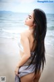 A woman standing on a beach next to the ocean.