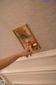A person pointing at a plaque on a wall.