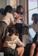 A group of young women in school uniforms sitting on a window sill.