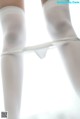 A close up of a woman's legs in white stockings.