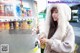 A woman standing in front of a vending machine.