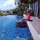 A woman sitting on the edge of a swimming pool.