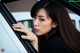 A woman looking out the window of a car.