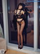 A woman in lingerie standing in front of a glass door.