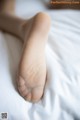 A close up of a person's foot on a bed.