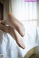 A close up of a person's feet on a bed.